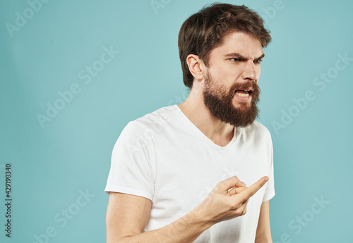 Aggressive man on blue background shows forefinger stress irritability cry