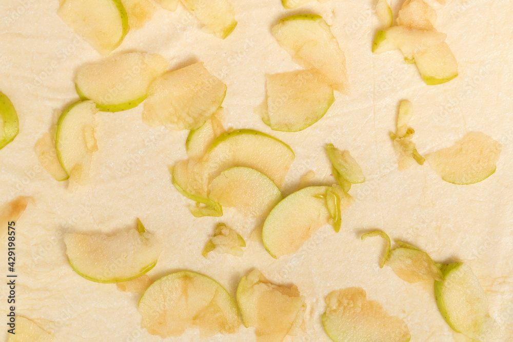 Pieces of apples are laid out on top of the dough. Apple pie making process Pieces of apples are laid out on top of the dough. Apple pie making process