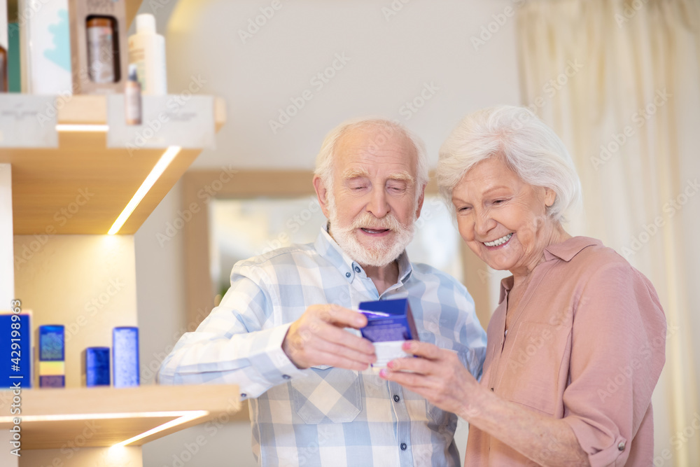 Fototapeta premium Elderly couple choosing cosmetics in a beauty shop