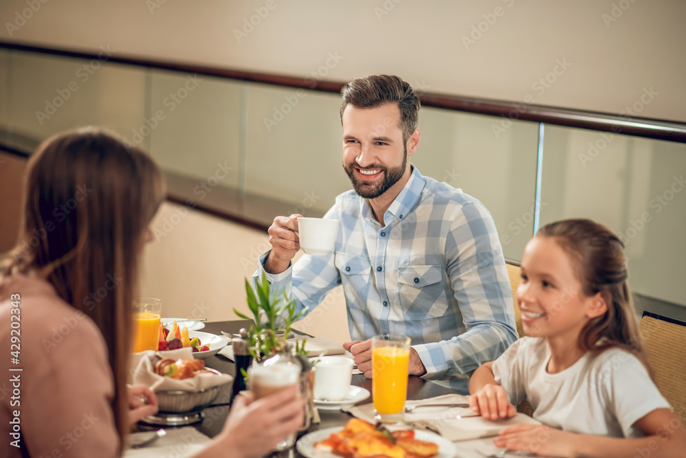 Dad having breakfast with his daughter and looking happy Dad having breakfast with his daughter and looking happy