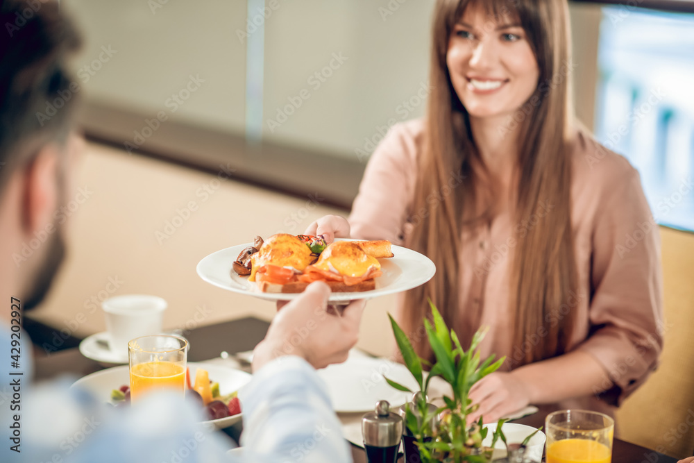 Man giving a plate with food to his smiling wife