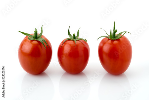 three red cherry tomato , datterino type isolated on white, copy space