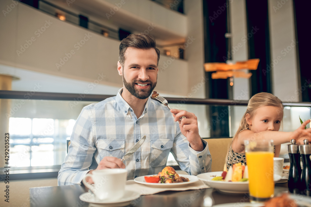 Young father having a breakfast with his daughter
