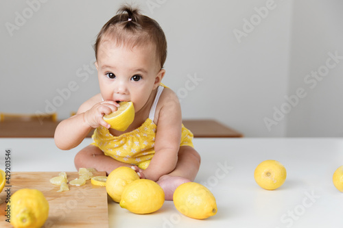 Cute baby girl biting in a lemon