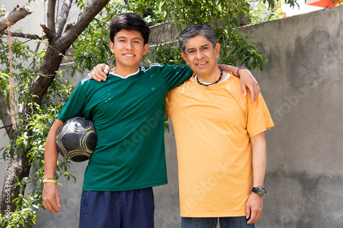 portrait of father and son smiling while hugging each other