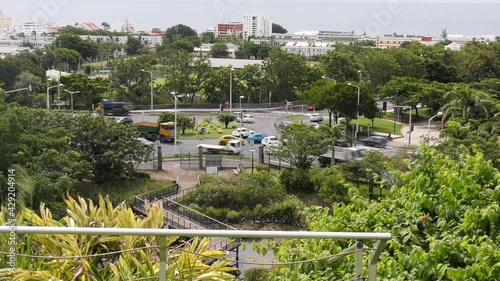 Timelapse du trafic routier sur un rond point de Saint Denis de l'île tropicale de La Réunion avec la mer en arrière plan et sous un ciel nuageux