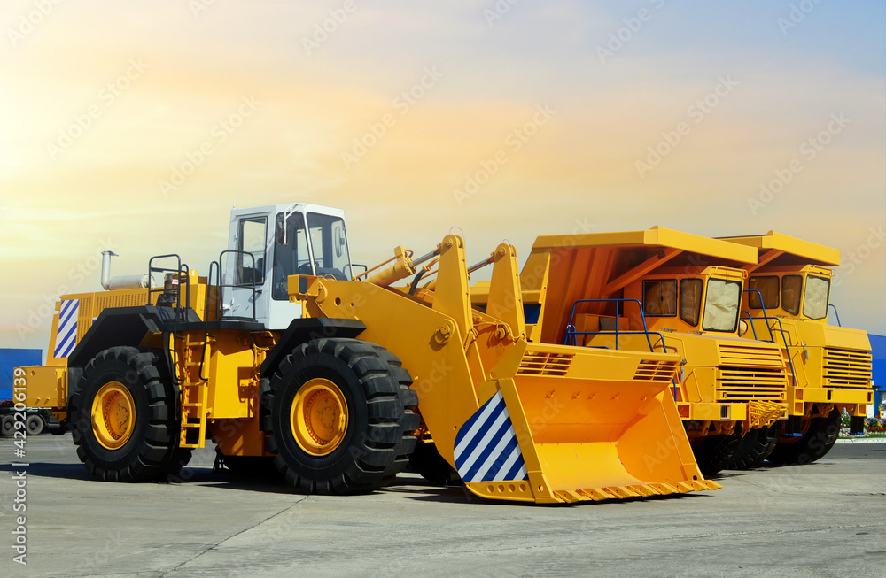 Wheel loader and mining truck. Heavy construction machinery and mining equipment. Front-end loader or all-wheel bulldozer and dump trucks