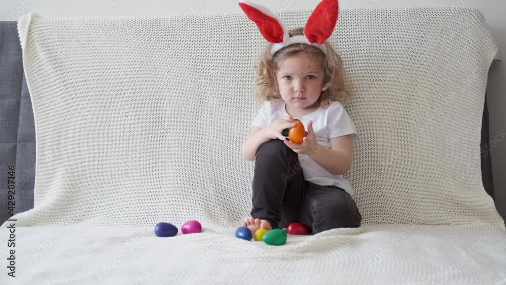 4k. Funny little cute girl in bunny ears play with eggs. easter 4k. Funny little cute girl in bunny ears play with eggs. easter