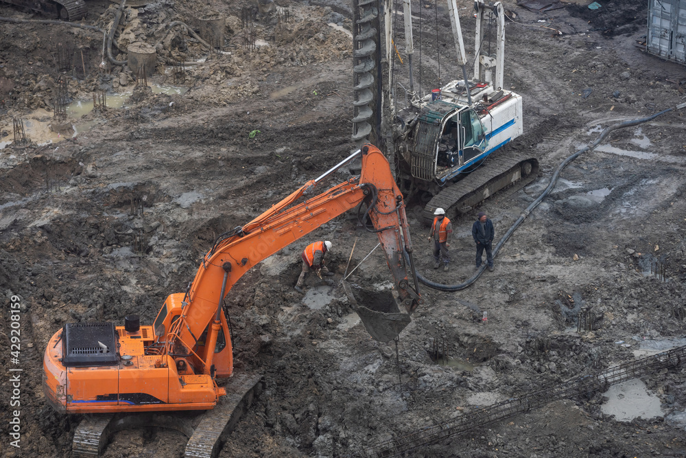 Wheel loader Excavator with backhoe unloading sand at eathmoving works in construction site. Wheel loader Excavator with backhoe unloading sand at eathmoving works in construction site.