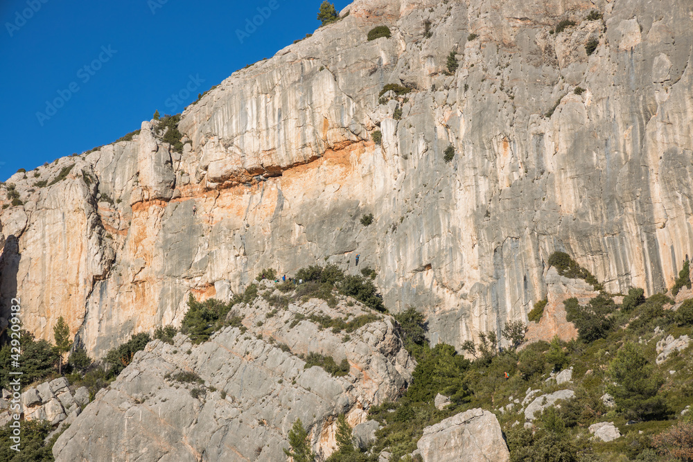 Southern slope of Montagne Sainte-Victoire in southern France with men climbing the rock face