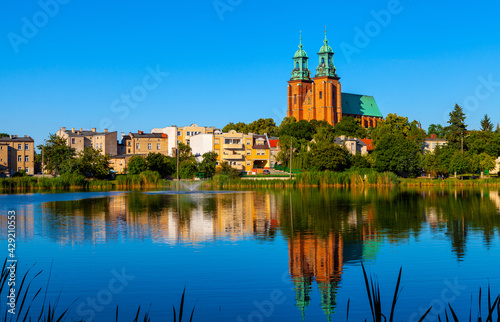 Cathedral of Virgin Mary Assumption and St. Wojciech at Lech Hill across Jelonek Lake in old town historic city center of Gniezno in Grater Poland