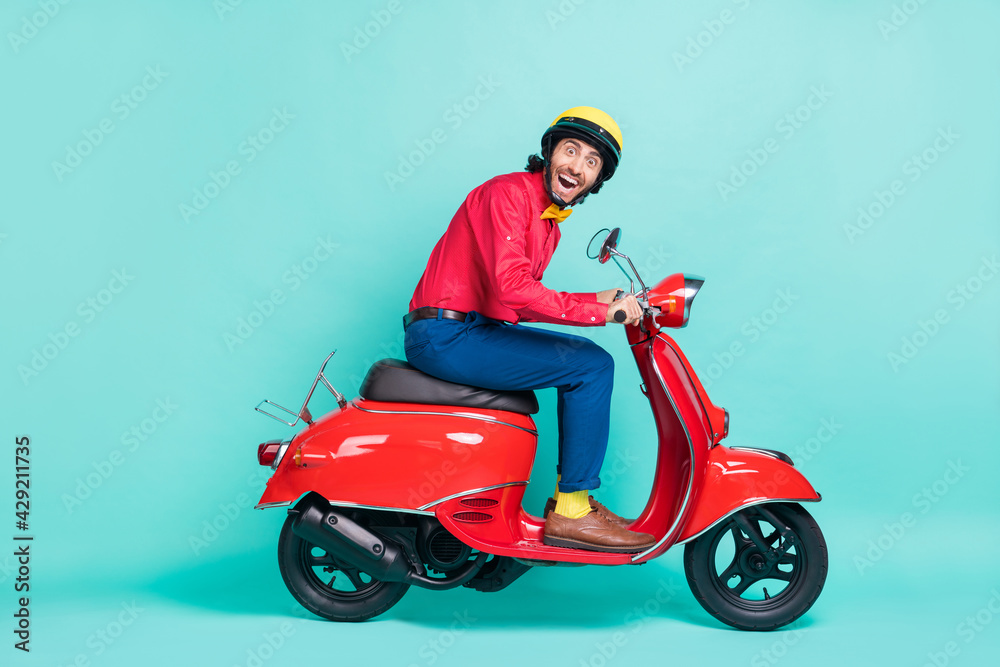 Full body profile side photo of funky amazed man ride motorbike isolated on pastel teal color background Full body profile side photo of funky amazed man ride motorbike isolated on pastel teal color background
