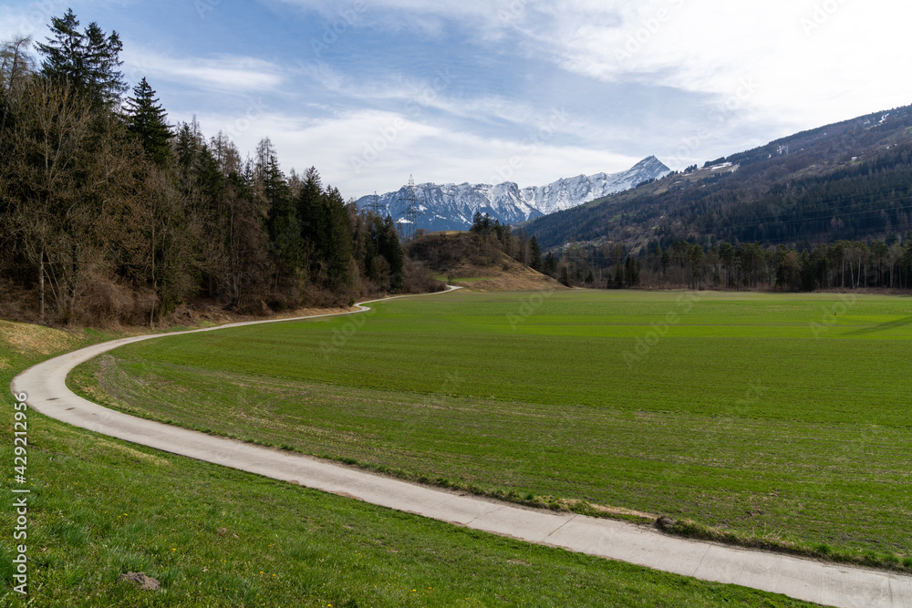 mountain landscape in the Swiss Alps with snow-covered peaks and green meadows in the spring