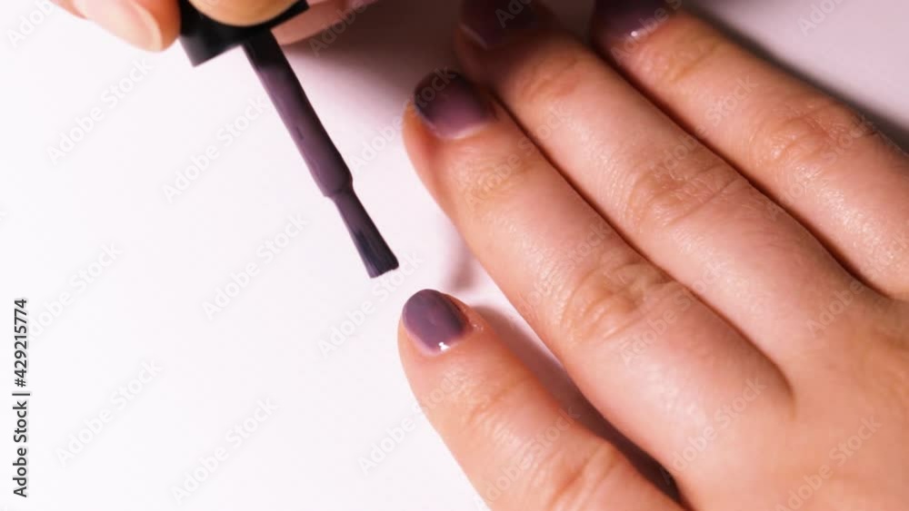 Application of colored violet gel polish on the nail. Manicure at home. Application of colored violet gel polish on the nail. Manicure at home.