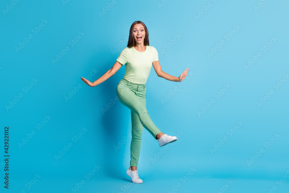 Full length photo of sweet charming young woman wear green outfit dancing isolated blue color background