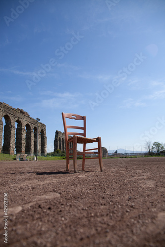 antique chair placed in the center of an old football field with aqueducts