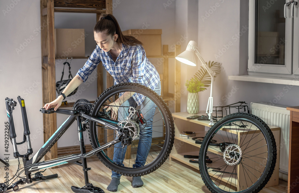 Woman is performing maintenance on his mountain bike. Concept of fixing and preparing the bicycle for the new season Woman is performing maintenance on his mountain bike. Concept of fixing and preparing the bicycle for the new season