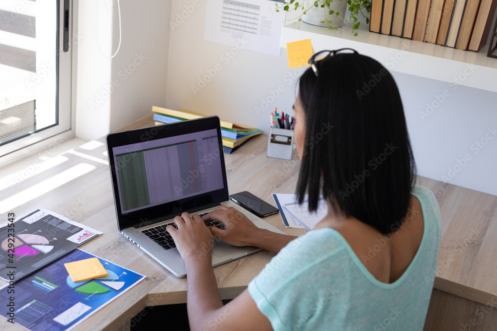 Mixed race transgender female working at home using laptop Mixed race transgender female working at home using laptop