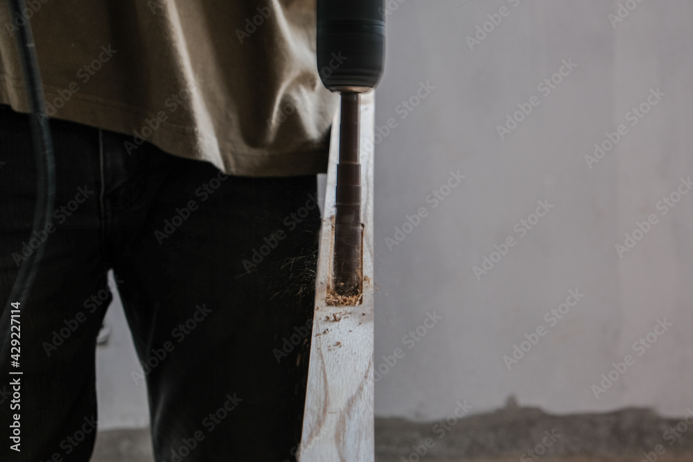 Naklejka premium Carpenter working on wood cutting machine during wooden door furniture manufacturing