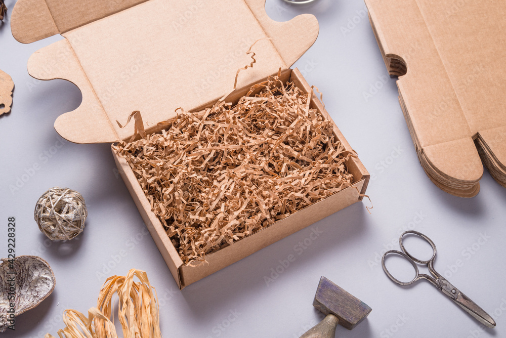 Brown shredde paper filler in cardboard box for packaging - obrazy, fototapety, plakaty 