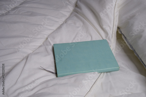 Notepad on the bed. Interior. Mockap. White bedding.