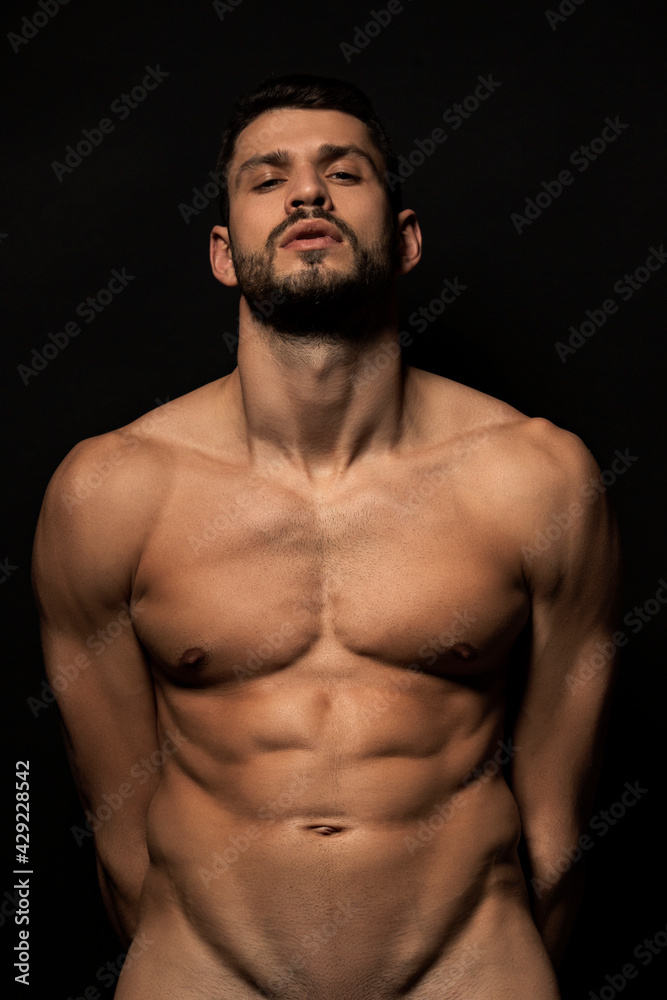 Handsome sport sexy stripped guy portrait on isolated black background Handsome sport sexy stripped guy portrait on isolated black background