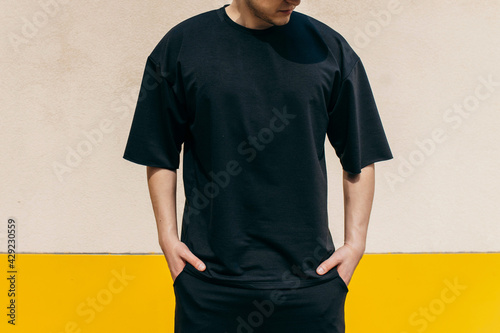 Man wearing black blank t-shirt with space for your logo or design. Mock up