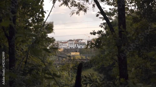 white houses with orange roofs, Roman stone walls and cranes peeking out from the undergrowth and camera movement that hides the city.