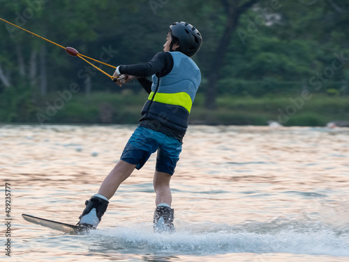 Asian young child boy wake boarding