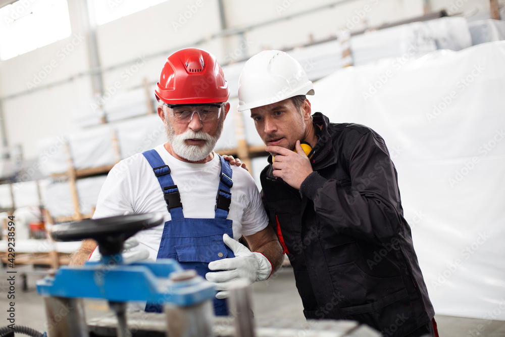 Portrait of workers in factory. Colleagues with helmet working in factory. Portrait of workers in factory. Colleagues with helmet working in factory.
