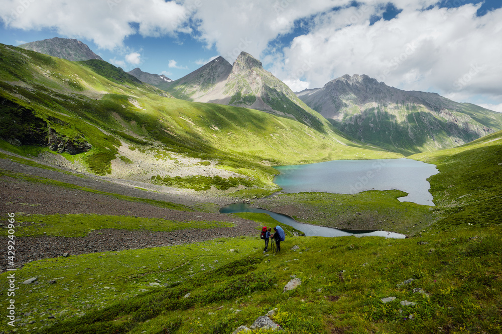 women traveler with backpack and looking at amazing mountains and lake, travel in nature on vacation concept women traveler with backpack and looking at amazing mountains and lake, travel in nature on vacation concept