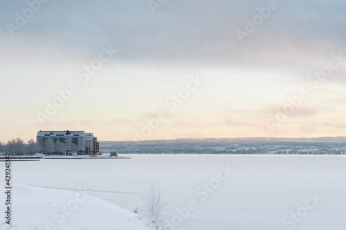 View of the frozen and snow-covered Storsjön Lake in Östersund in the light of sunset