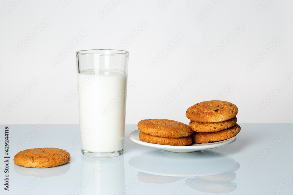 A glass of milk and cookies on a table on a white background. A glass of milk and cookies on a table on a white background.