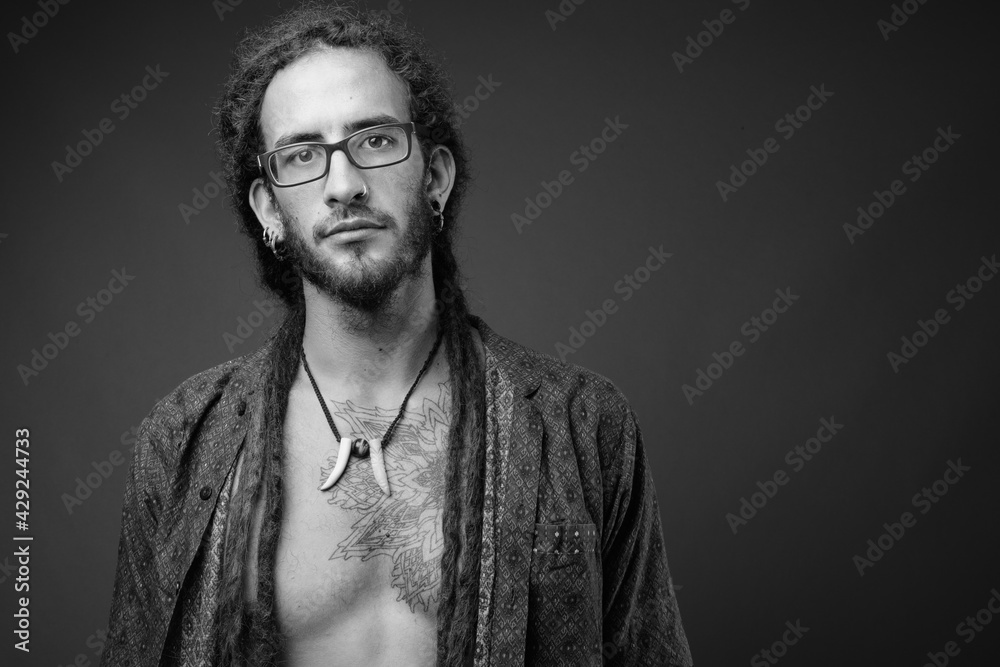 Fototapeta premium Young handsome Hispanic man with dreadlocks in black and white