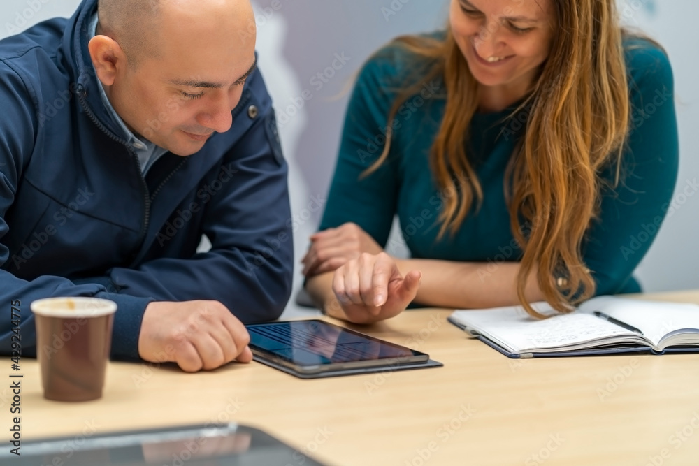 A Manager looking at a chart on a tablet while his colleague presents.Working as a team is key to success.Business office concept
A Manager looking at a chart on a tablet while his colleague presents.Working as a team is key to success.Business office concept