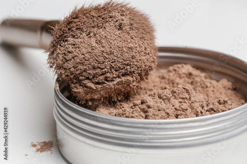 A jar of organic non-toxic chemicals free dry shampoo. DIY project for healthy low toxic living. Simple shampoo powder containing just natural ingredients, cocoa powder, cornstarch and essential oil.