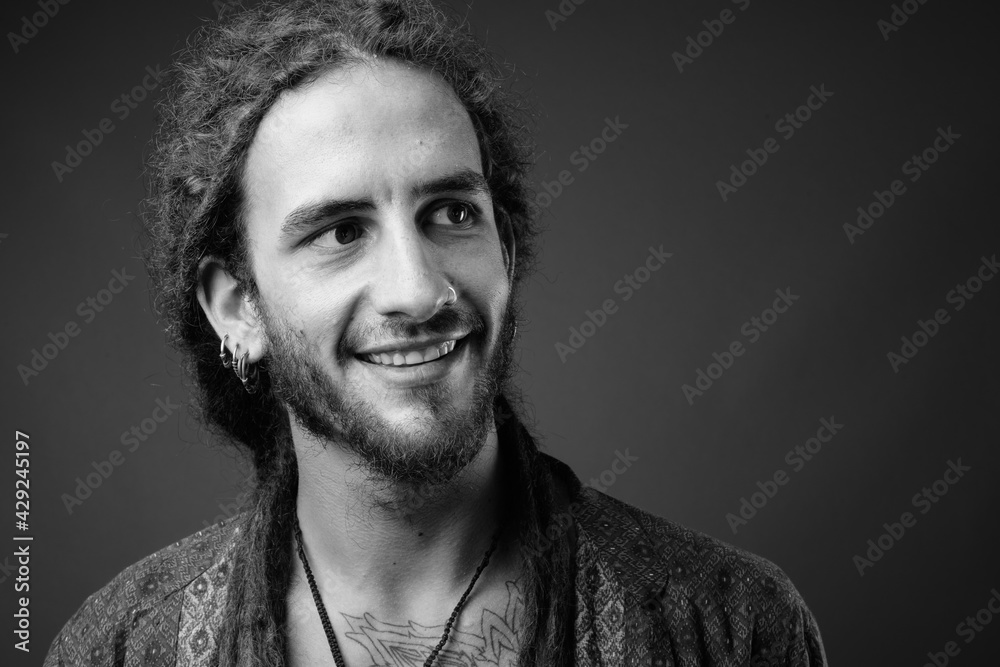 Fototapeta premium Young handsome Hispanic man with dreadlocks in black and white