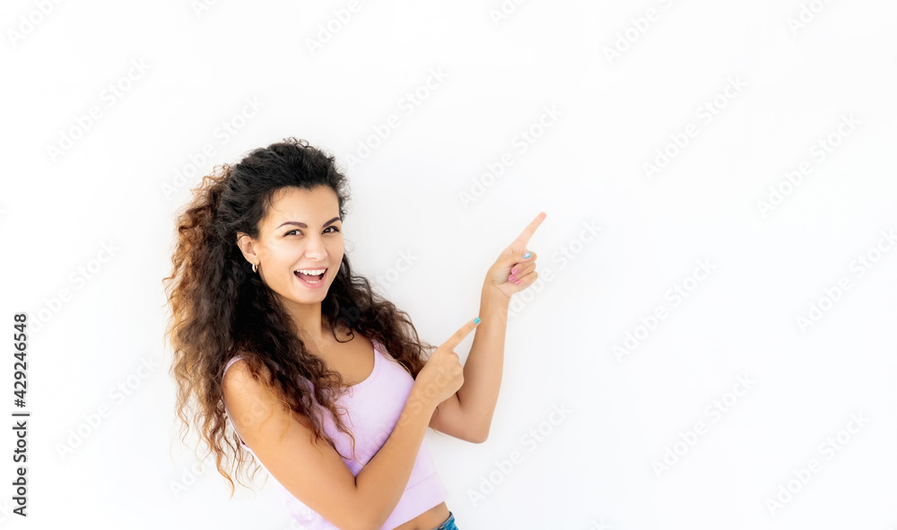 Cheerful young girl standing sideways and pointing up Cheerful young girl standing sideways and pointing up
