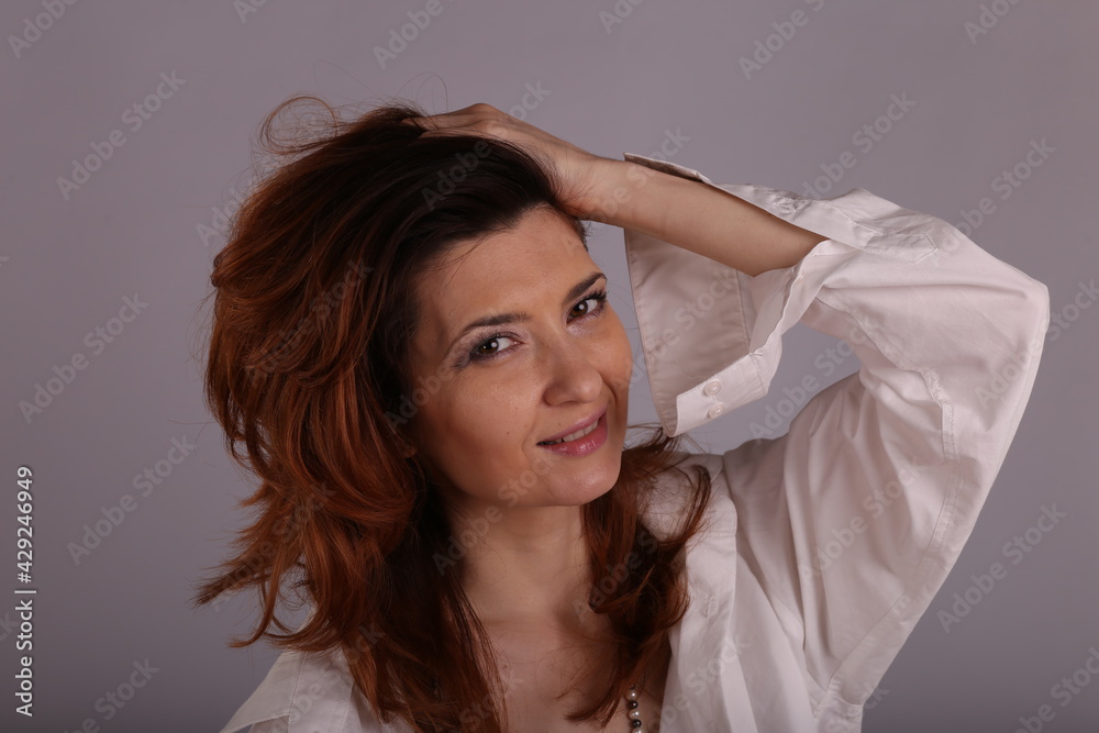 Fototapeta premium a beautiful woman straightening her hair with her hands