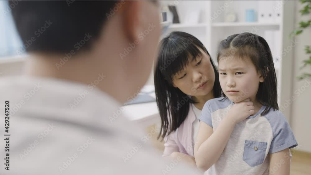 Asian mother and daughter with sore throat visiting doctor, medical services Asian mother and daughter with sore throat visiting doctor, medical services
