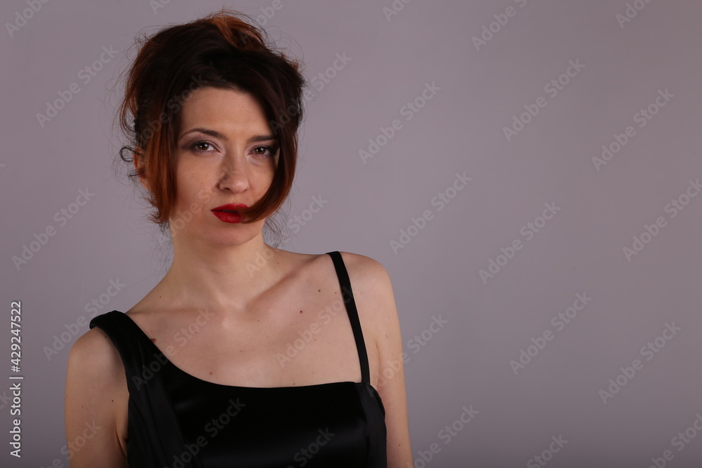 Elegant slender woman in black dress on grey background Elegant slender woman in black dress on grey background