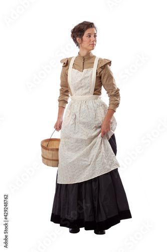 Photography Young prairie woman with apron looking back and holding skirt and a basket isola