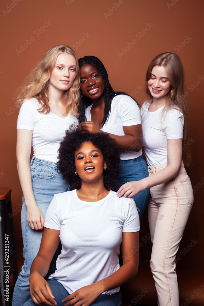 Fototapeta premium young pretty caucasian, afro, scandinavian woman posing cheerful together on brown background, lifestyle diverse nationality people concept