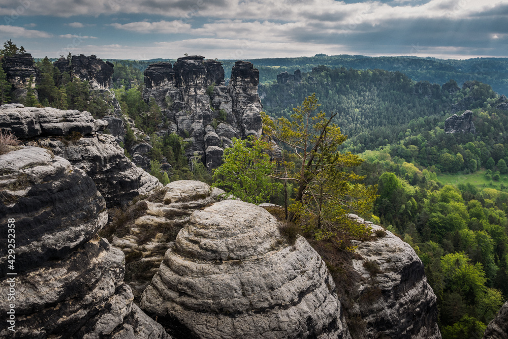 View from viewpoint of Bastei Bridge in Saxon Switzerland Germany to the town at the mountain on a cloudy day
