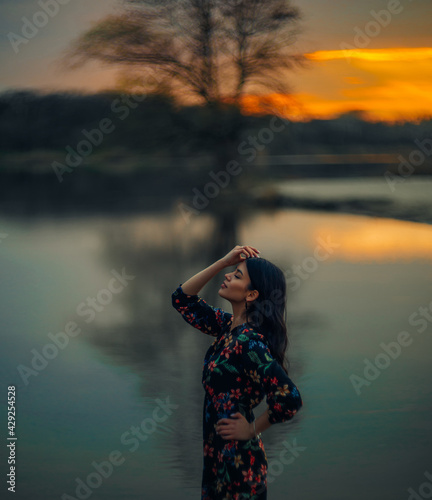 Wallpaper Mural Young woman rests near lake at sunset. Torontodigital.ca