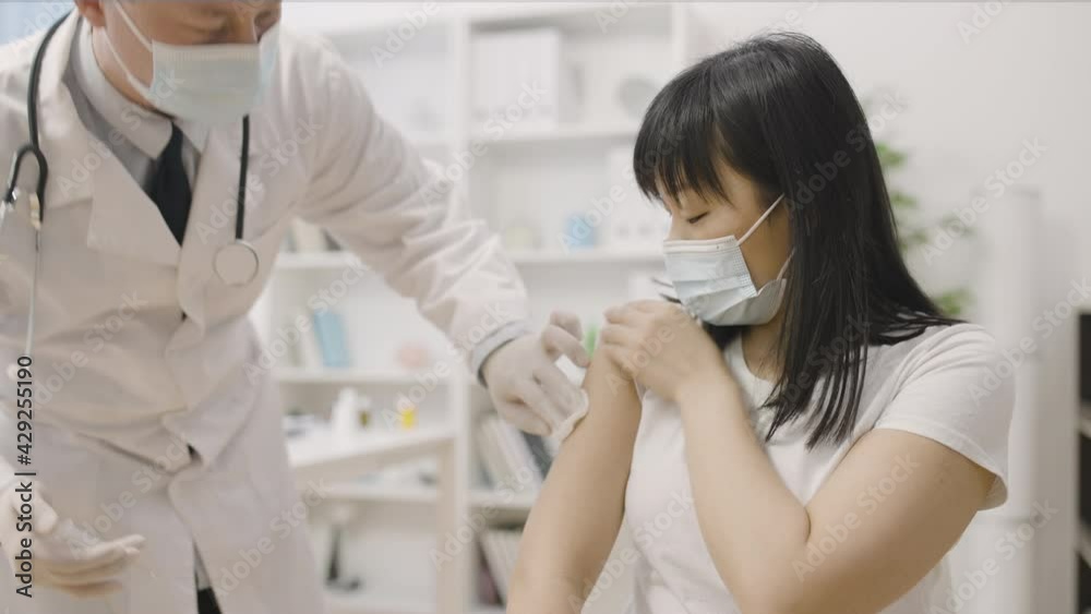 Doctor injecting vaccine to asian woman, immunization against disease, medicine Doctor injecting vaccine to asian woman, immunization against disease, medicine
