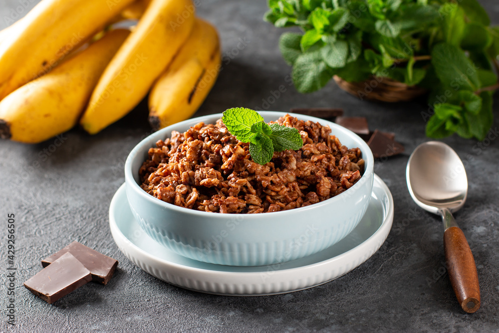 Chocolate oatmeal with banana - healthy vegetarian breakfast on a wooden table Chocolate oatmeal with banana - healthy vegetarian breakfast on a wooden table