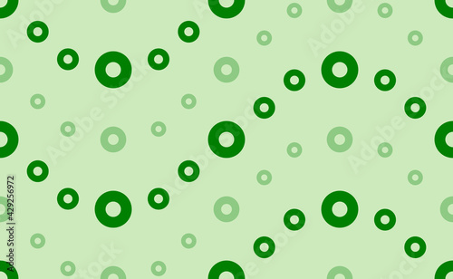 Seamless pattern of large and small green record media symbols. The elements are arranged in a wavy. Vector illustration on light green background