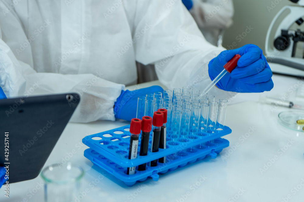 Asian medical scientists in PPE protective suit research for virus pandemic vaccine in clinical laboratory Asian medical scientists in PPE protective suit research for virus pandemic vaccine in clinical laboratory