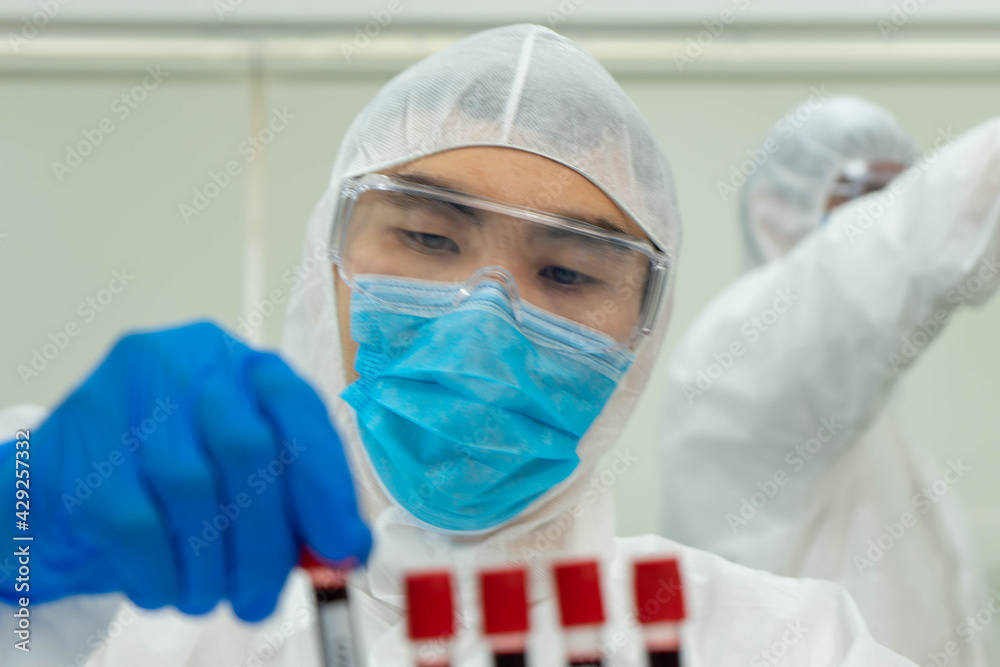 Asian medical scientists in PPE protective suit research for virus pandemic vaccine in clinical laboratory Asian medical scientists in PPE protective suit research for virus pandemic vaccine in clinical laboratory